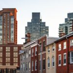 Brick rowhomes with tall buildings in the background neediest areas