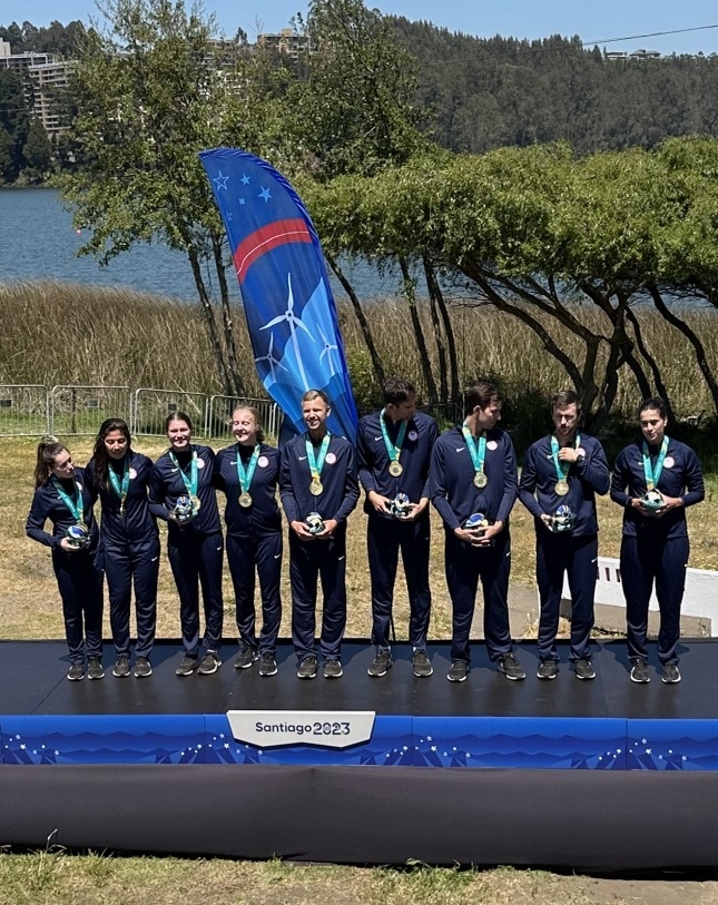 The mixed eight USRowing team at the 2023 Pan American Games . The nine people in the photo have gold medals hanging from their necks. 