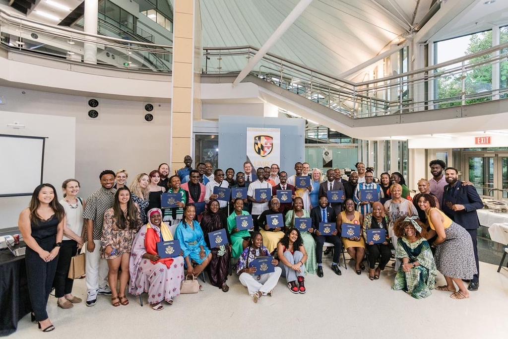 A large group of young African leaders gather for a photo in an atrium
