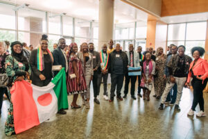 A large group of young African leaders gather in a lobby