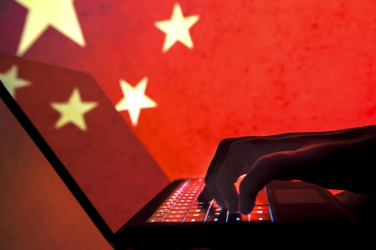 China Hands typing on a lap top with a red background and gold stars China