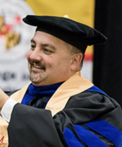 Portrait of Halverson wearing doctoral graduation cap and gown