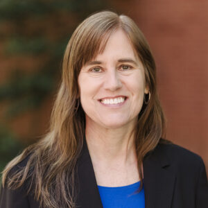 Portrait of Jenny Carr wearing a blue shirt and blazer outside