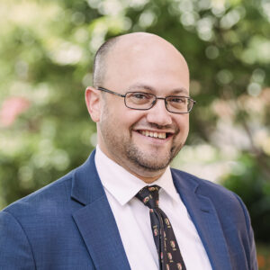 Portrait of Jake Weissmann wearing a blue suit and tie