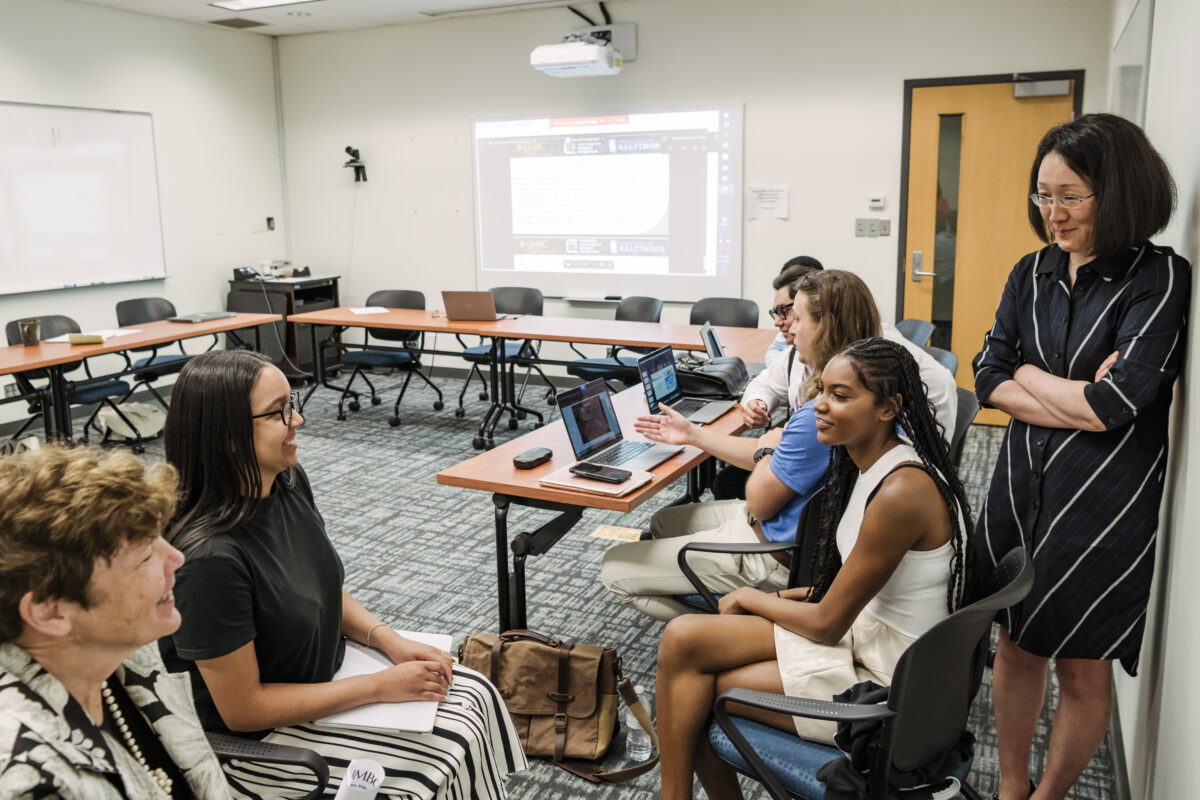 Two professors talk with students 