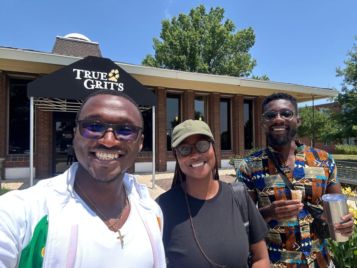 Buhlebakhe Ncube stands with other Young African Leaders smiling at the camera on a sunny day in front of a brick building.