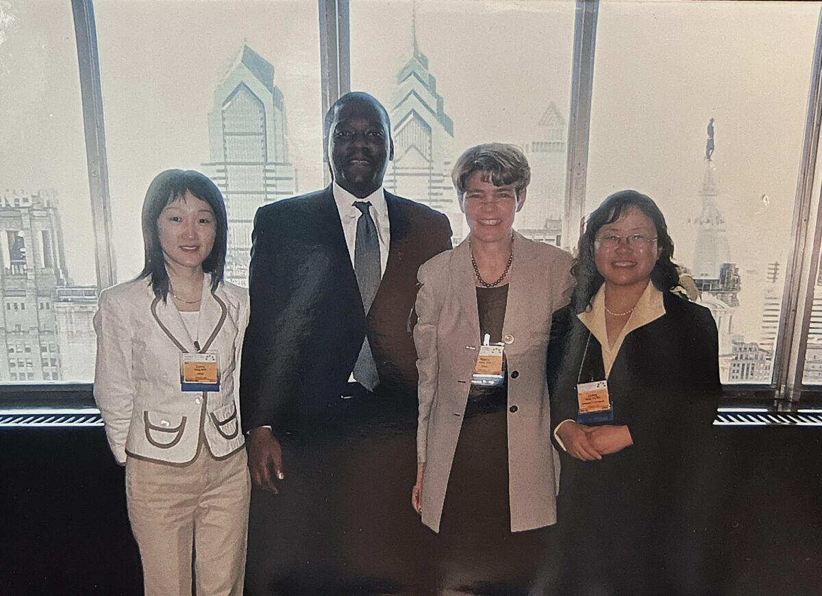 Three graduate students take a picture with Nancy Miller, a professor, with the city of Philadelphia in the background