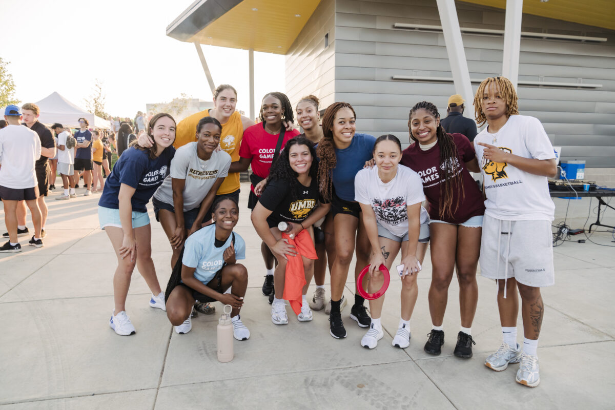 A group of student-athletes smile and pose for a group photo