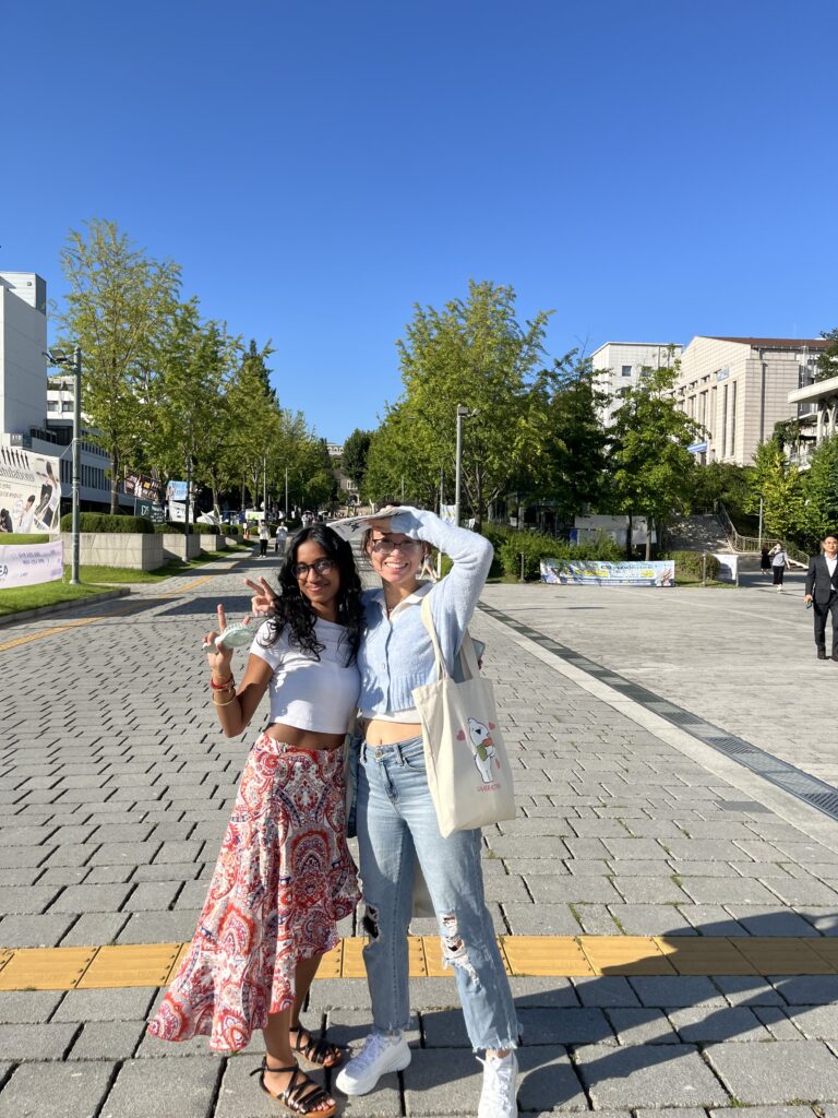 Two college students stand on a brick laid street