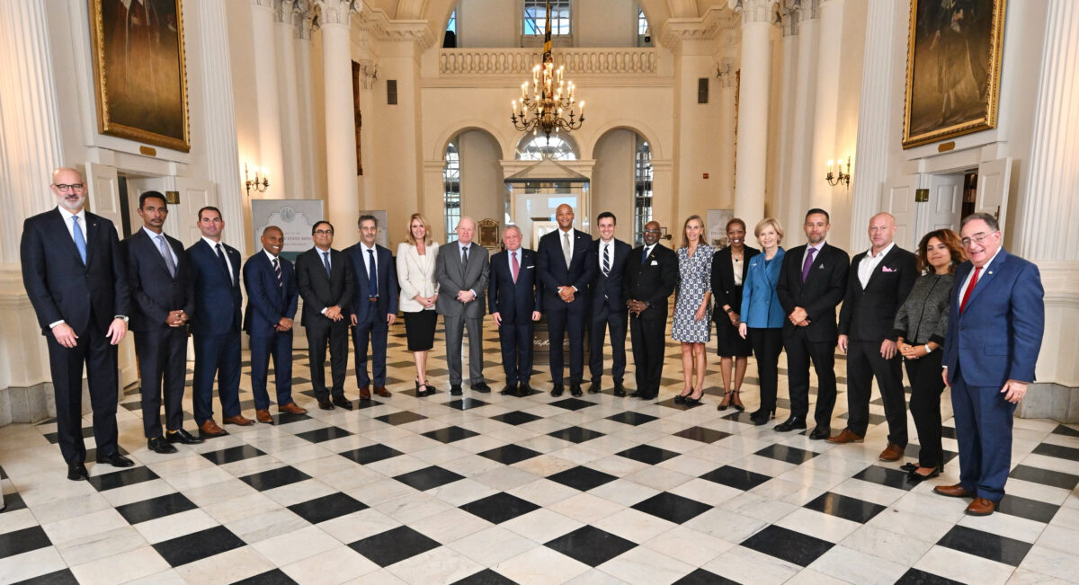 A group of dignitaries poses in a large government ballroom in Annapolis