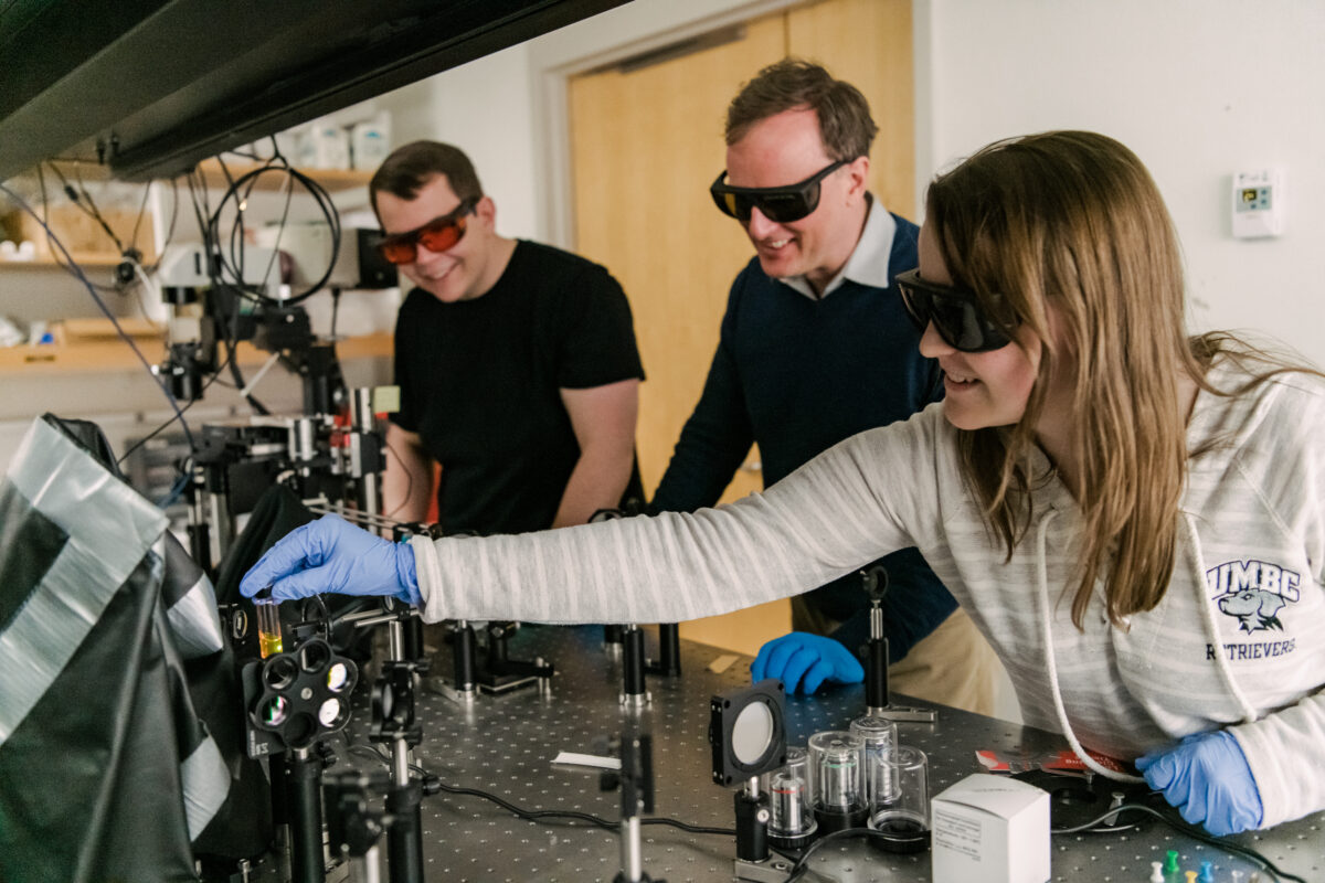 three people work on a laser layout in Matt Pelton's quantum photonics laboratory