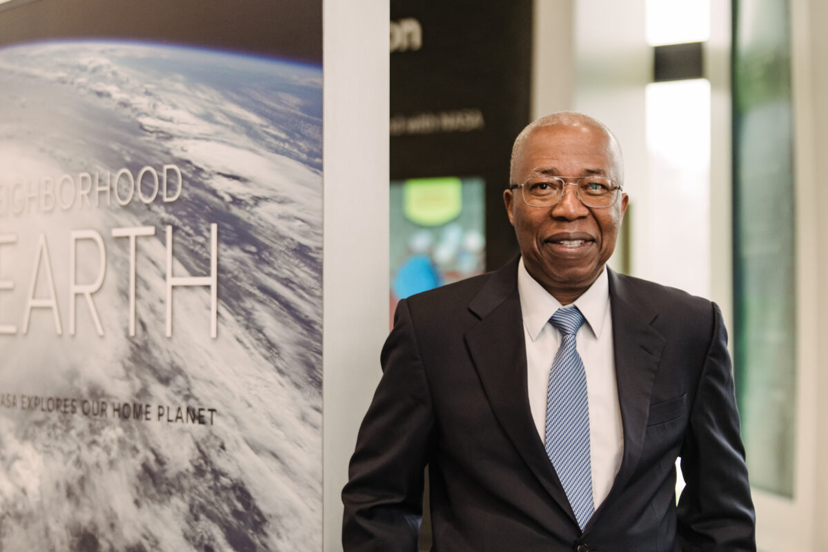 Man standing who is wearing a suit and tie, smiling at the camera at NASA Goddard Space Flight Center