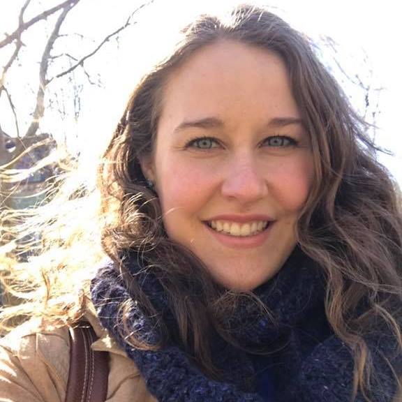 portrait of woman in winter jacket and scarf, sunlight glowing on her hair