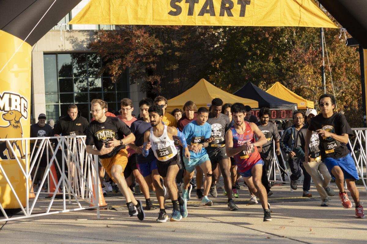 Many people starting to run at the starting line of a 5k race. People are in the motion of running. 