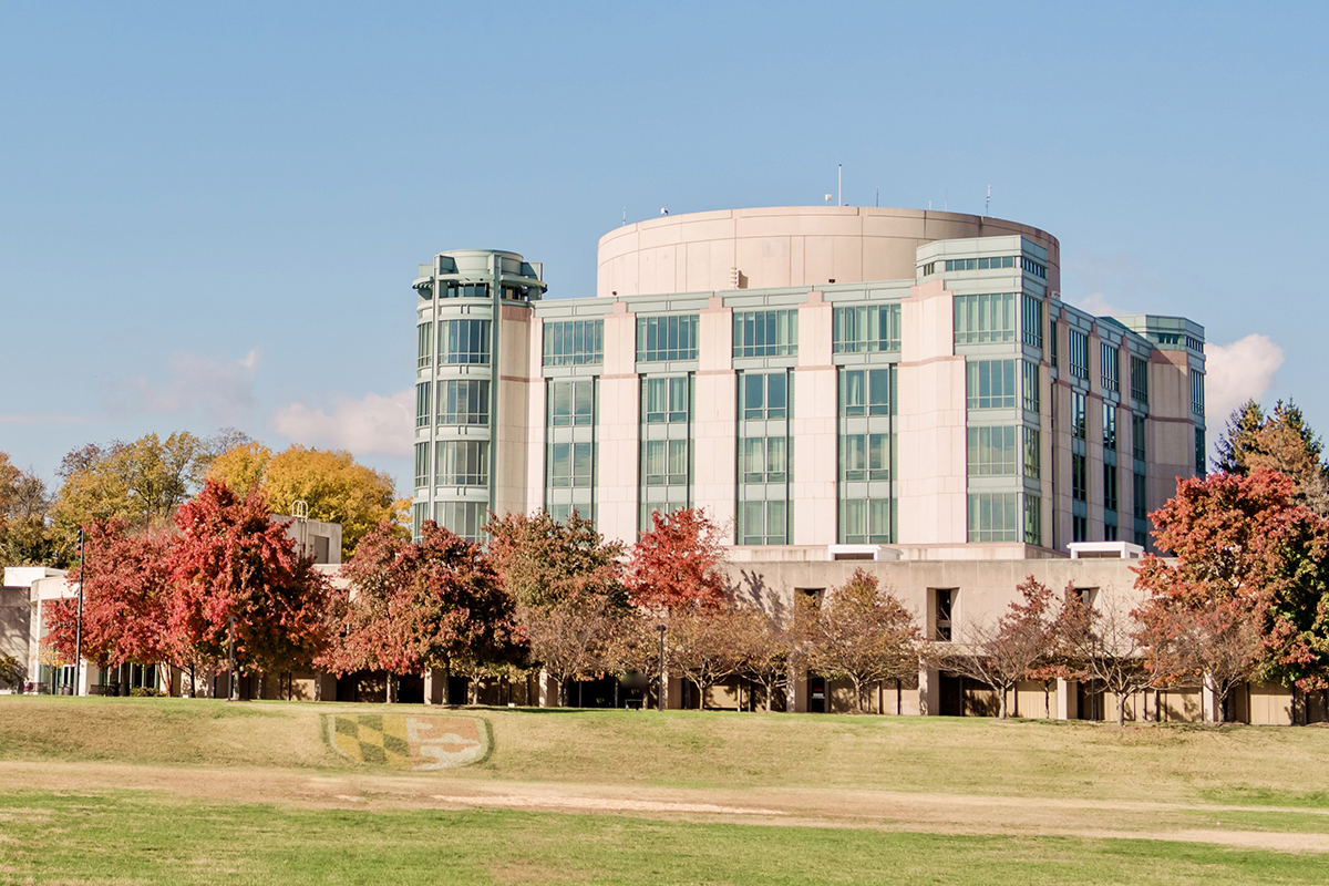 A white and teal colored building surrounded by trees showing fall colors.