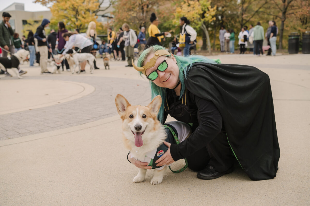 a woman (left) posing with her dog. the dog has its tongue sticking out in glee.  