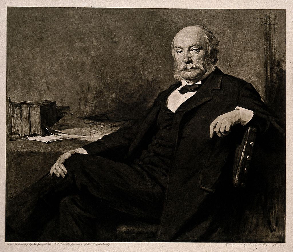 Black-and-white picture of a man in formal attire sitting at a desk.