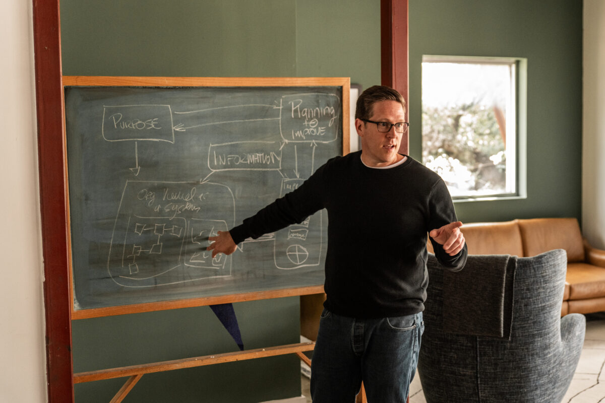 David Williams teaching at a blackboard on the framework of his new book, Quality as an Organizational Strategy: Building a System of Improvement.