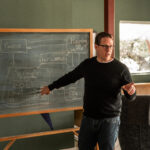 David Williams teaching at a blackboard on the framework of his new book, Quality as an Organizational Strategy: Building a System of Improvement.