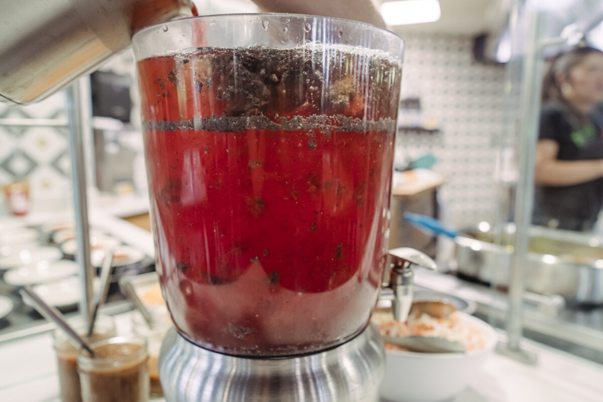 A large plastic beverage container holds a strawberry and chan seed beverage