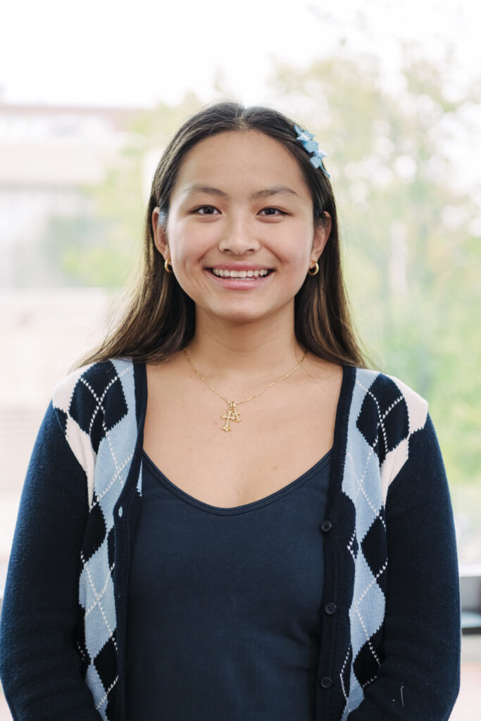 headshot of a woman with a blue argyle cardigan