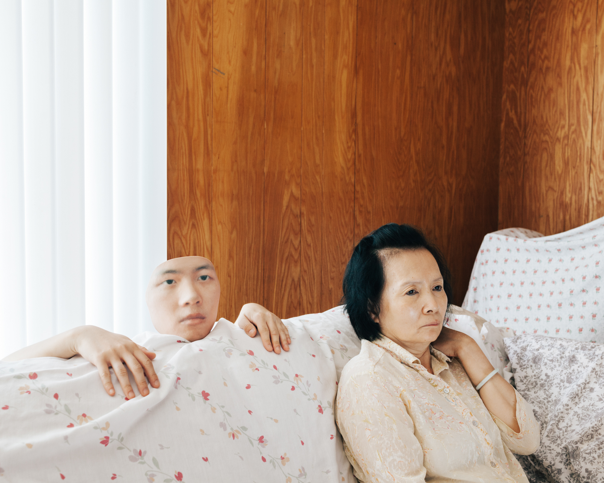 A person sits on a couch. To their right, a disembodied head and pair of hands emerge from the back of the couch.