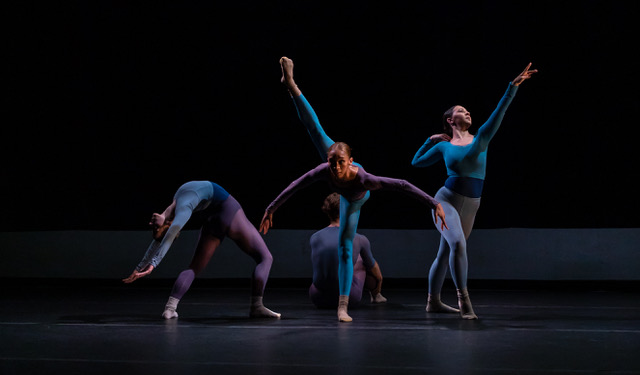 4 dancers performing ballet on stage, wearing blue and purple costumes. Each move expressively and dynamically 