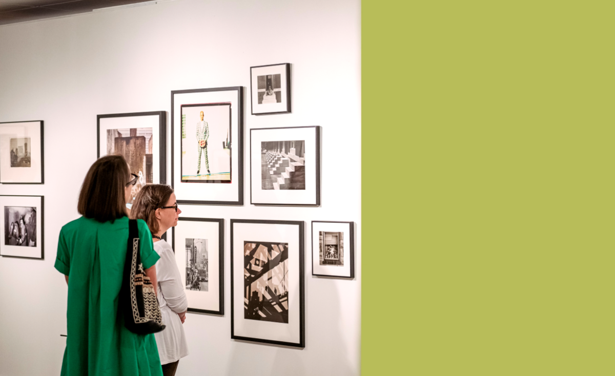 Gallery guests looking at framed images on the wall