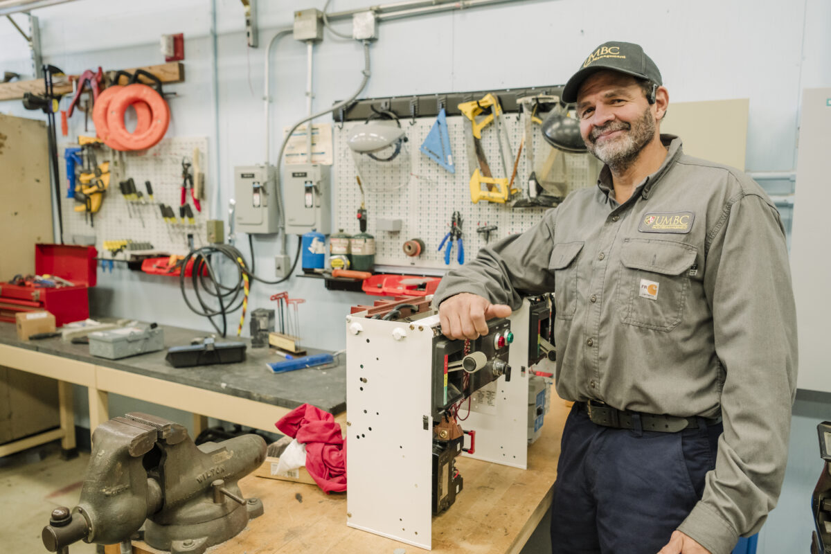 a man stands in a electrical shop surrounded by tools of the trade