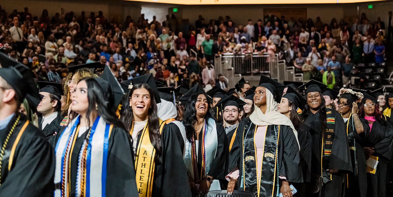 a diverse group of young women and men wearing graduation caps and gowns