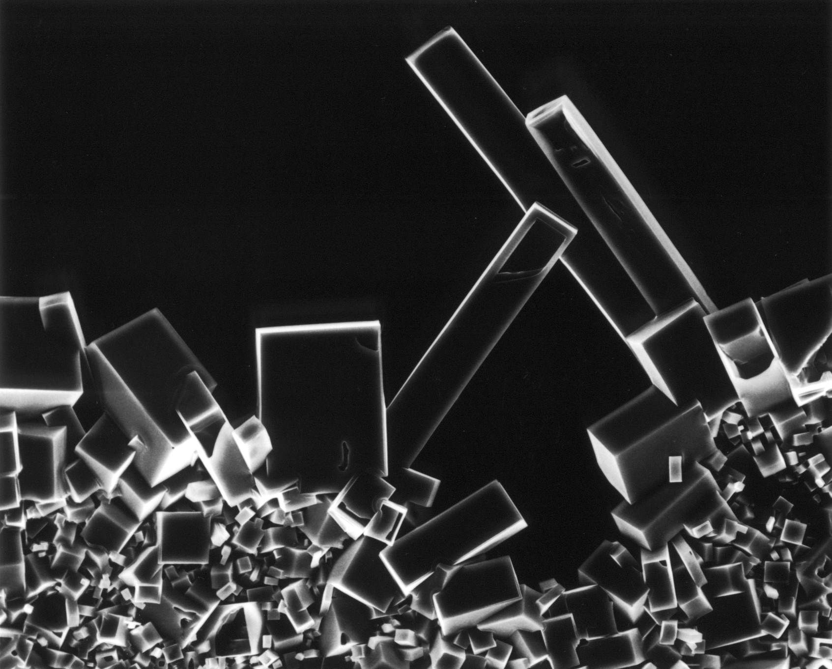 In an abstract looking black and white photo, crystal forms are stacked on top of one another.