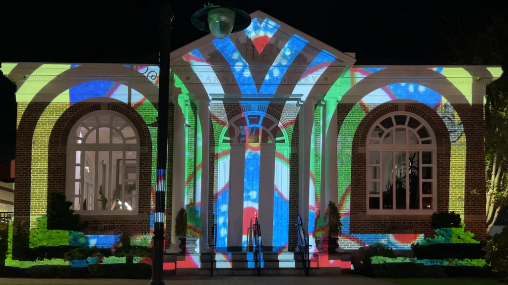 A colorful design is projected onto the façade of a building.