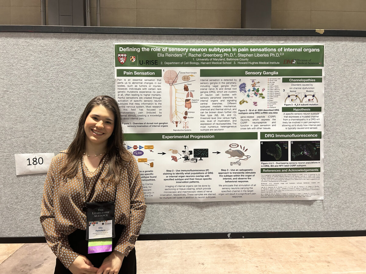woman stands next to research poster