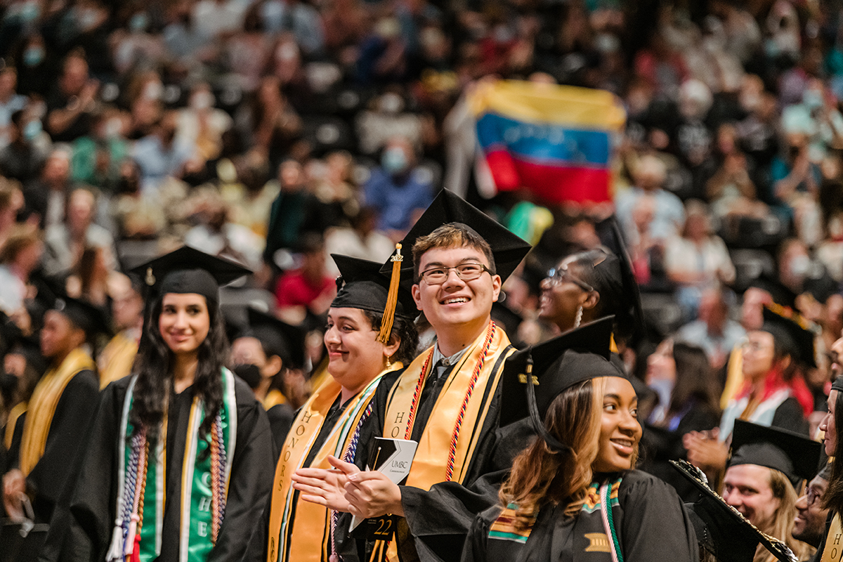 a diverse group of students standing in a crowd at umbc graduation