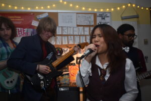 a woman sings into a microphone in a small musical venue