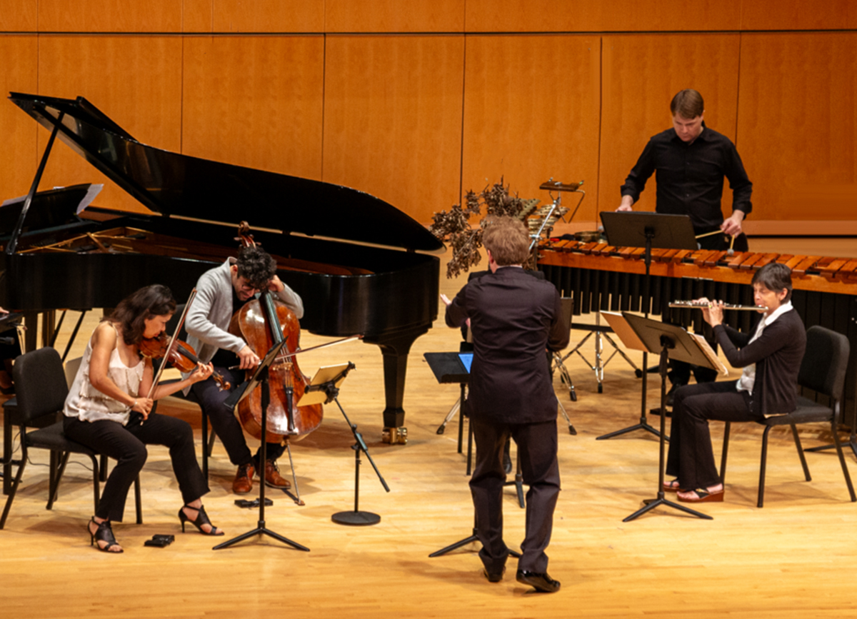 Musicians perform on a concert stage.