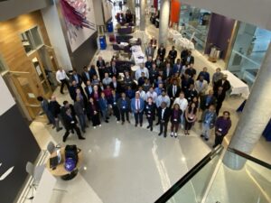 Photograph from above shows large number of IEEE Baltimore Technical Colloquium attendees gathering in a corridor for a group picture.