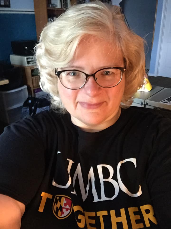 a woman with short hair wearing a UMBC together shirt