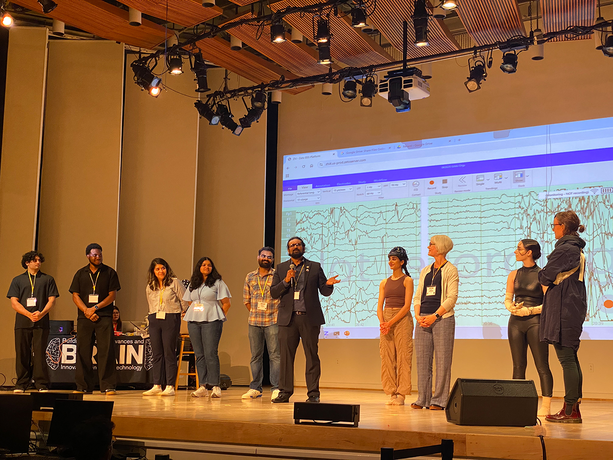 UMBC students and professors who worked on the project gather on the stage after the dance performance. From left to right are Viraj Janeja, Oritsejolomisan Mebaghanje, Golnaz Moharrer, Sruthi Sundharram, Parthan Olikkal, Ramana Vinjamuri, Juju Ayoub, Andrea Kleinsmith, Sarah McHale, and Anne Clemmensen.
    
    Photo Credit: Niloufar Sarmast