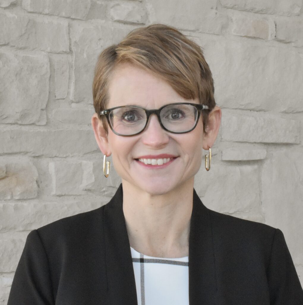 a white woman with short blond hair and glasses