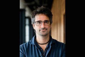 Head shot of man in glasses; he is developing an AI assistant for scientists