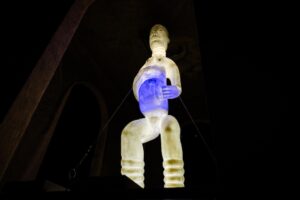 Against a dark background, an artistic rendering of a person is lit in white, except for a blue area in the middle.