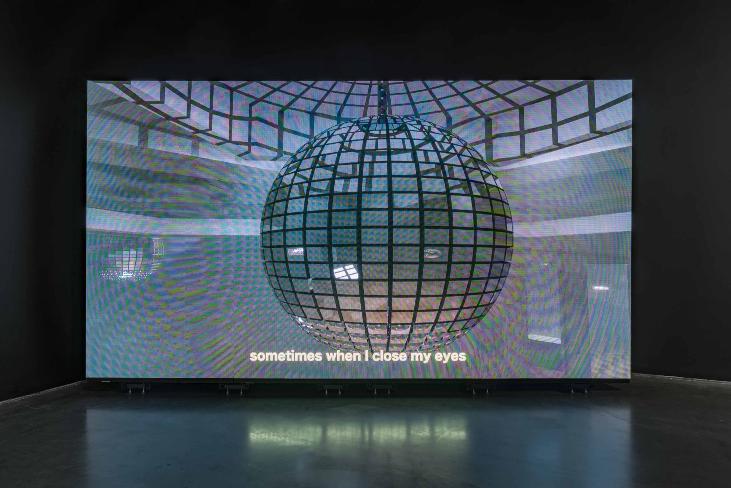 We see a film or video being screened in a theatre, with the words "sometimes when I close my eyes" across the bottom of the image.