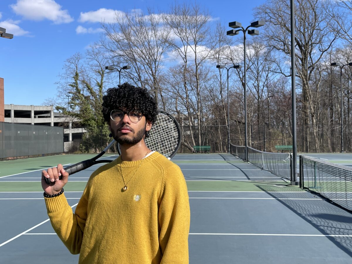 young man holding tennis racket and standing on tennis court