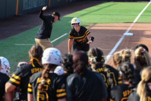 Emily Riggs at softball game, looking at teammates