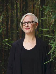 Headshot of Elizabeth Johnson wearing glasses and a dark cardigan.