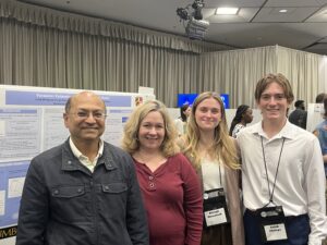 Rileigh Mansfield with mentors and co-presenter in front of their research poster