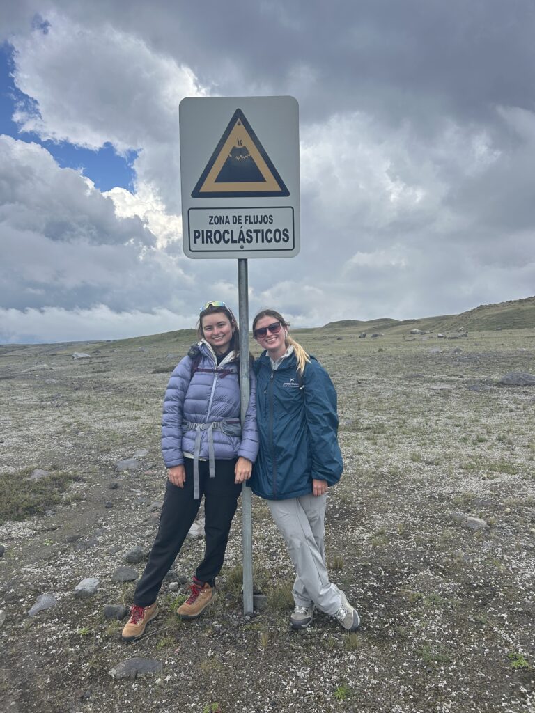 Rileigh Mansfield and Emilia Pelegano-Titmuss stand by a sign warning of volcanic flows