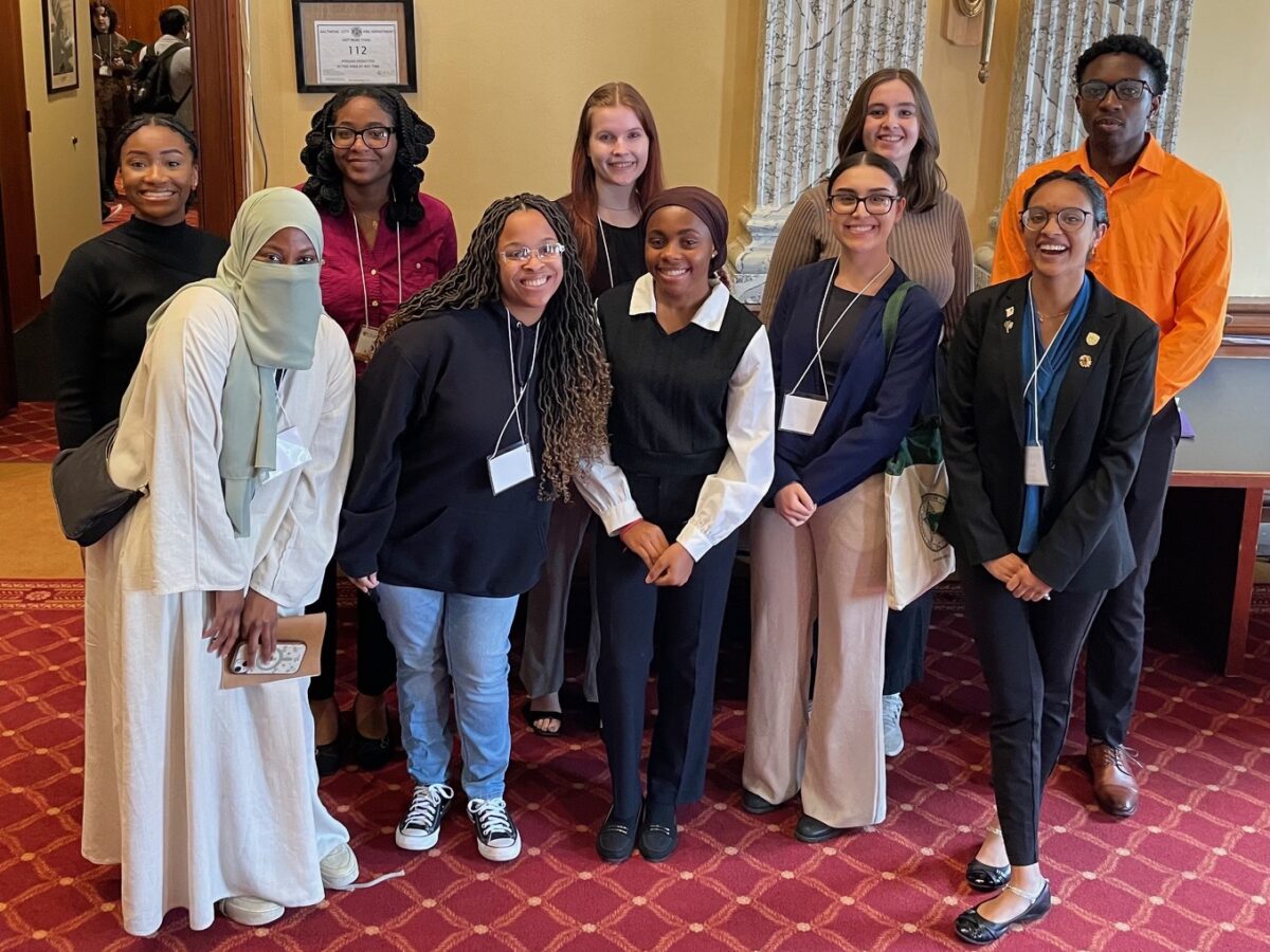 Several students gather for a photo in Baltimore's City Hall as they take a moment from the community engagement efforts they volunteered to do. 