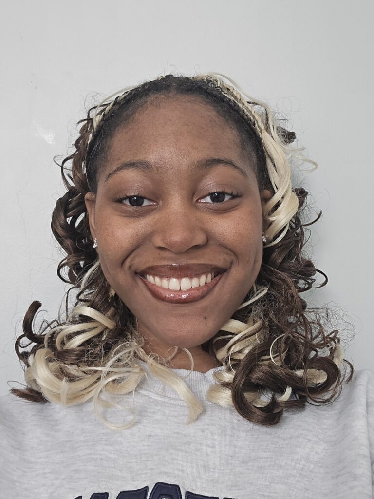 headshot of essence jones with a big smile and brown and blond curls